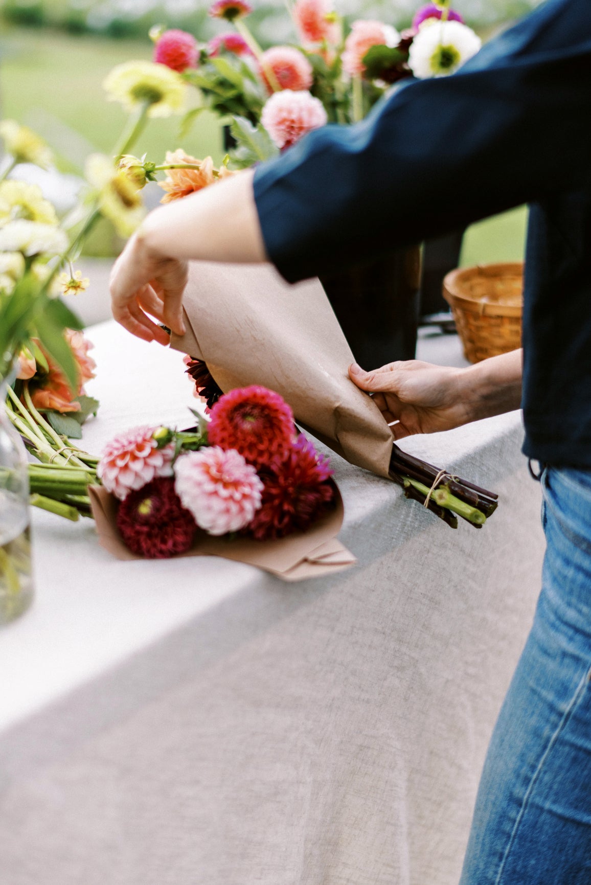 Woman wrapping Dahlia CSA Flowers in Kraft Paper